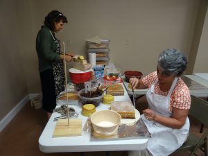 Melinda Howze and Andrea Phillips assembling castle cake 